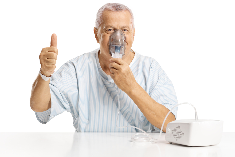 mature male patient using a nebulizer machine